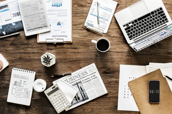 Spend Money Wisely Without Sacrificing Your Lifestyle A messy table with a laptop and financial documents for planning to spend money wisely.